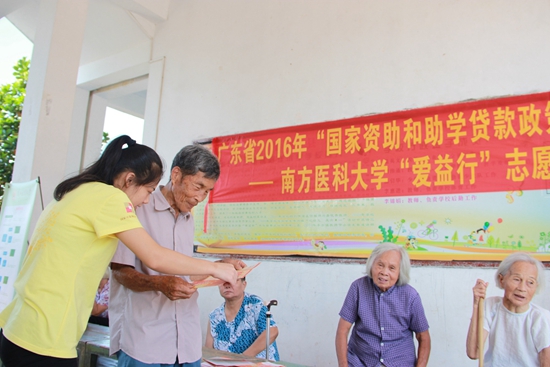 4-村民在“资助宣传”摆摊处认真咨询国家助学贷款政策.jpg