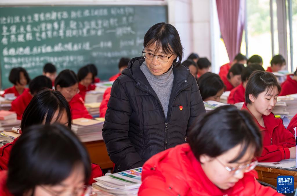 云南丽江华坪女子高级中学党支部书记、校长张桂梅（中）在教室里检查学生上课情况（2020年12月1日摄）。
